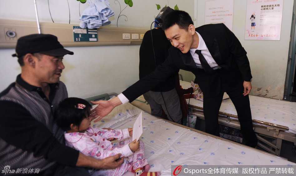 病房中杨鸣俯身与小朋友亲切交流，眼神温柔充满关爱，传递着无限暖意