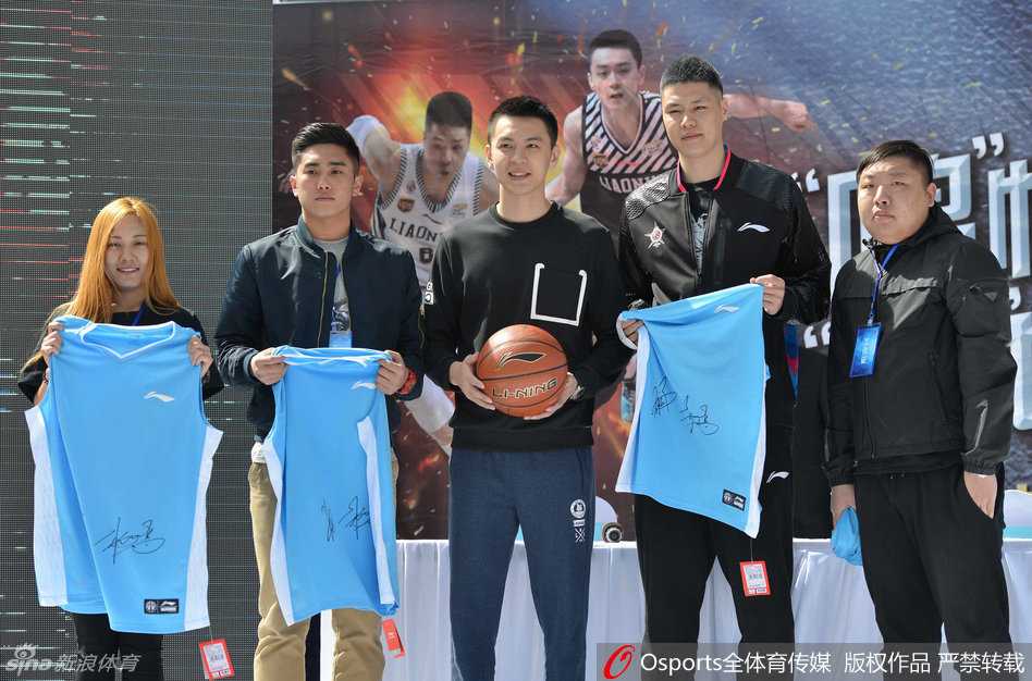 杨鸣低头为热情的球迷认真签名，笔尖划过篮球与照片，专注的神情透露出他对每一位支持者的尊重与珍视。