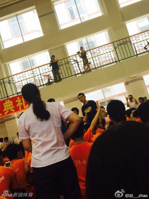 校园行见证传奇人气,杨鸣的篮球传承路 身穿笔挺衬衫的杨鸣,正在台上拿着话筒进行发言,他神情专注,眼神中透露出对篮球事业的坚定与热爱。