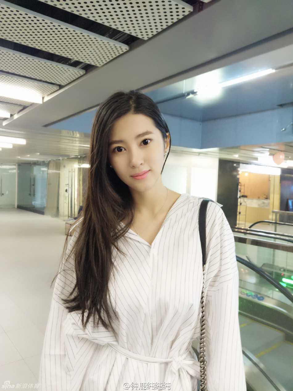 夕阳的余晖染红了天际，钟鹿纯背对镜头站在海水中，回眸的瞬间被抓拍，画面充满了电影般的质感，宁静而美好。