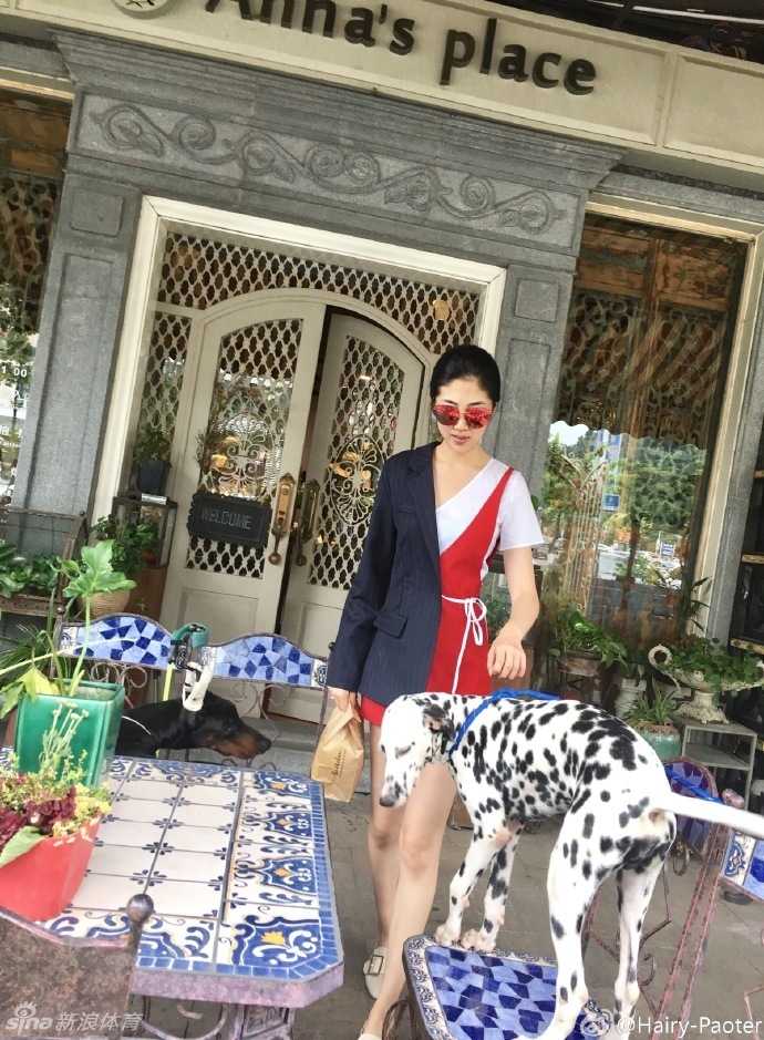 李跑身穿优雅的黑色无袖连衣裙出街，简约装扮难掩其出众气质，她单手插兜回眸一笑，一双修长美腿在街景中格外亮眼。