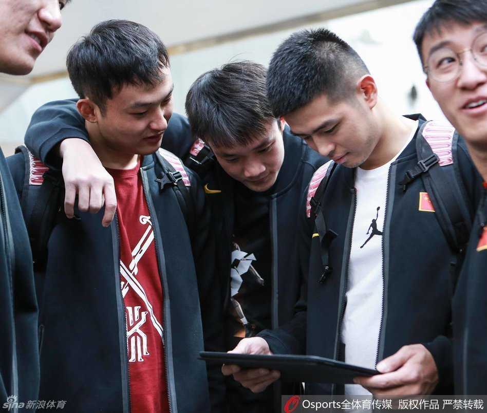 男篮海埂集训前夜 众将围睹科比传奇谢幕 男篮队员们紧紧围拢,目光锁定屏幕上的科比告别战,队长周鹏神情专注,丁彦雨航与队友们一同沉浸在传奇的最后一舞中。