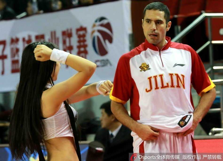 赛前热身时段，球员们在场上拉伸，背景中是正在认真准备的拉拉队员们，这种日常的共存状态，偶尔也会因为一个不经意的眼神而变得趣味十足。