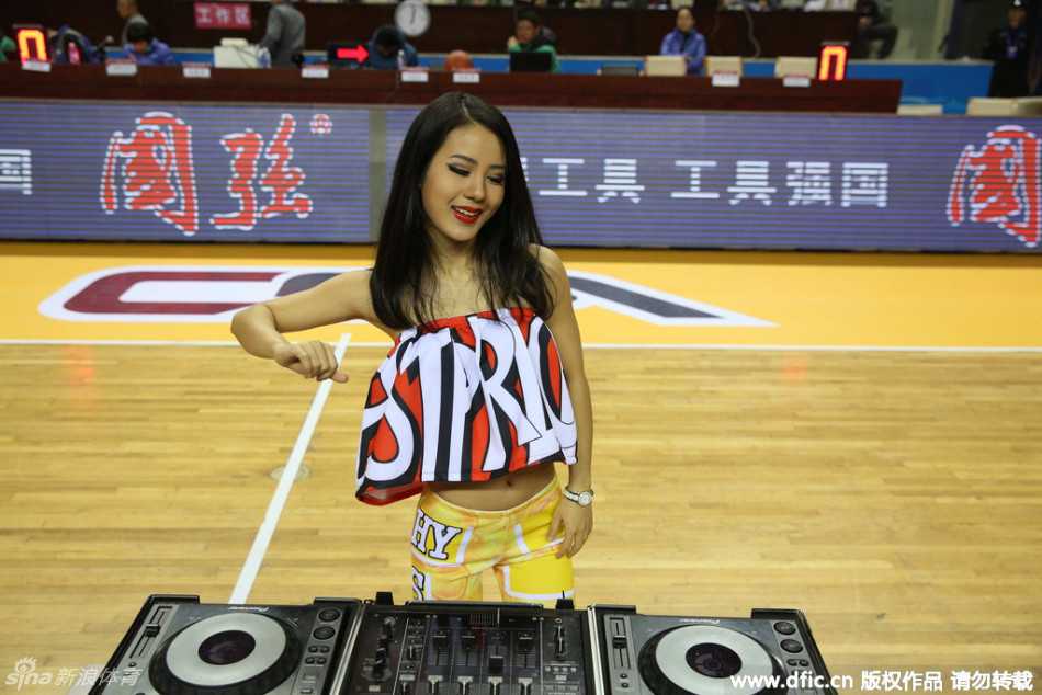 DJ台前的她微微侧身，双眸深邃而明亮，脸上带着自信迷人的微笑，仿佛在用眼神与全场观众进行无声的交流