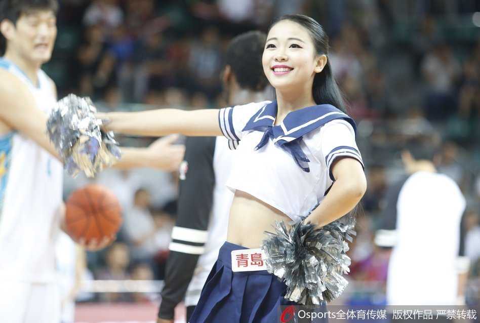 灯光下，啦啦队员们排列成行，以整齐划一的腿部动作展现着团队默契，修身的制服将她们优美的身姿衬托得淋漓尽致。