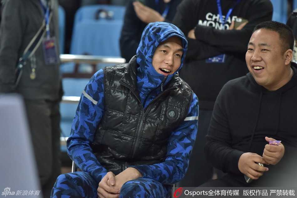 郭艾伦将羽绒服的帽子紧紧戴在头上，拉链拉到最高，整个人只露出一张脸，他轻轻撕开棒棒糖的包装纸，动作里透着几分迫不及待，仿佛一个在冬天偷偷享受零食的孩子。