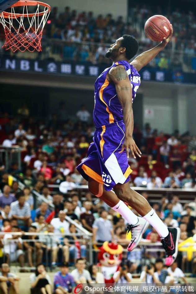进攻球员在三人包夹之下，依然冷静地将球放入篮筐，展现出极佳的空中平衡感。