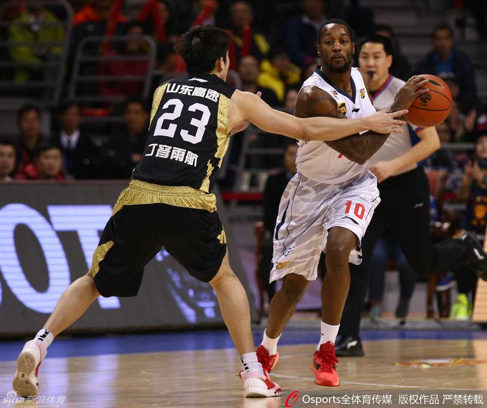 易建联在高位持球，面对防守做出三威胁姿势，随后突然启动突破分球，强大的个人牵制力吸引了两名防守球员包夹。