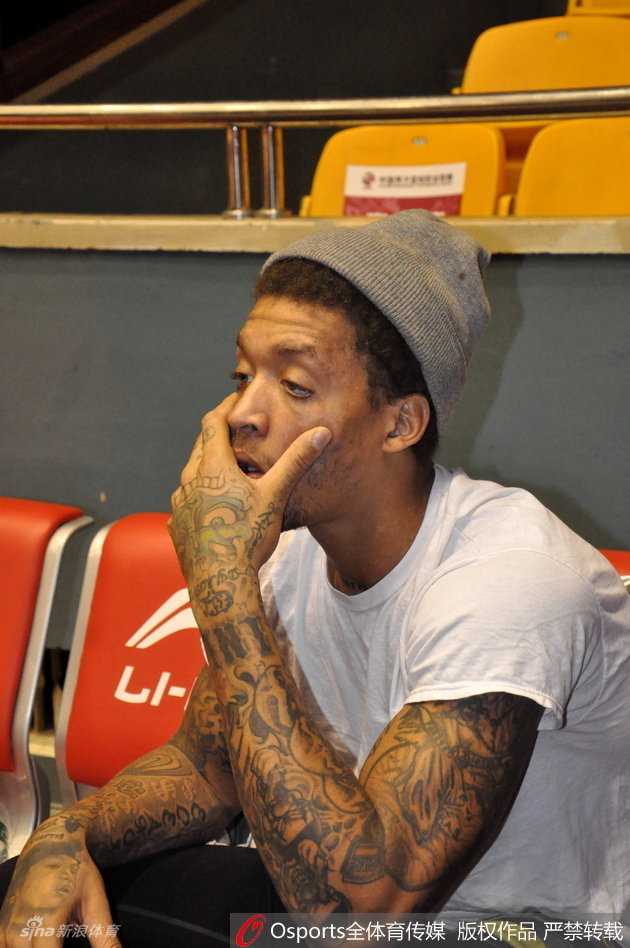 纹身背后的天才榜眼:比斯利的山东记忆与快意人生 比斯利戴着一顶黑色毛线帽,对着镜头自信地整理帽檐,眼神中带着一丝戏谑,仿佛在问大家自己这造型够不够帅气。