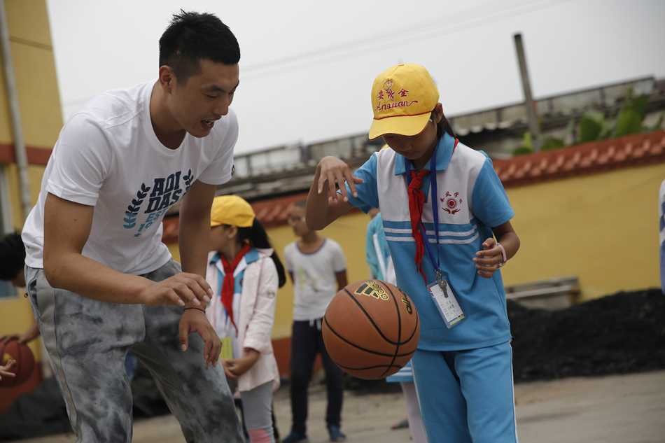 翟晓川站在讲台上客串体育老师，用粉笔在黑板上画着篮球战术简图，台下孩子们挺直腰板听得入神，简陋的教室因这一刻变得格外明亮