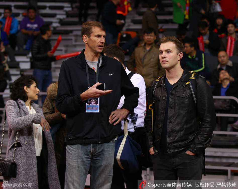 几位身材高大的外国球探专注地站立在场边，他们的目光紧紧锁定在场上训练的新疆队球员身上，其中一人正拿着手机进行拍摄，不愿错过任何一个细节。