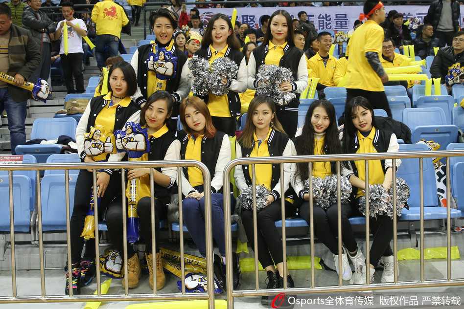 在球队暂停的间隙，几名篮球宝贝在场边排成一排，她们双手叉腰，眼神专注地望向场内，时刻准备着在哨响后再次登场，为观众带来精彩的表演。