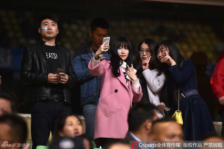 一名辽宁球迷在看台上站起身来，双手拢在嘴边，用尽全身力气呐喊指挥着助威节奏，额头青筋隐现，身后的四川球迷也纷纷侧目，仿佛被他一个人的气势所震撼。