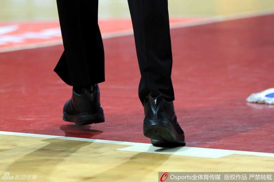 裁判脚上的“飞人”与篮协严规:回顾CBA球鞋门那夜的执法细节 裁判双手交叉站在记录台前,低头的瞬间球鞋特写尤为突出,飞人logo仿佛在无声地质疑着联赛规则的执行尺度