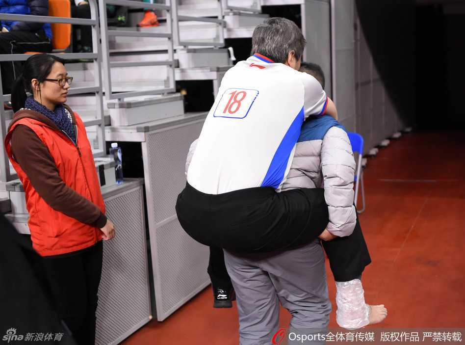 赛场惊魂一刻:裁判意外崴脚,被背出场外的特殊“伤员” 裁判坐在场边接受治疗,队医为其按压脚踝,受伤的裁判目光望向场内,心系未完成的比赛