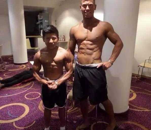 身高一米四七,精神顶天立地:英国亚裔小伙用肌肉铸就的生命传奇 与两位健身圈的前辈合影时,即使需要蹲下身来迁就镜头,他们的脸上也写满了对这位小个子勇士的敬佩。在这一刻,肌肉与肌肉之间,只有英雄相惜。