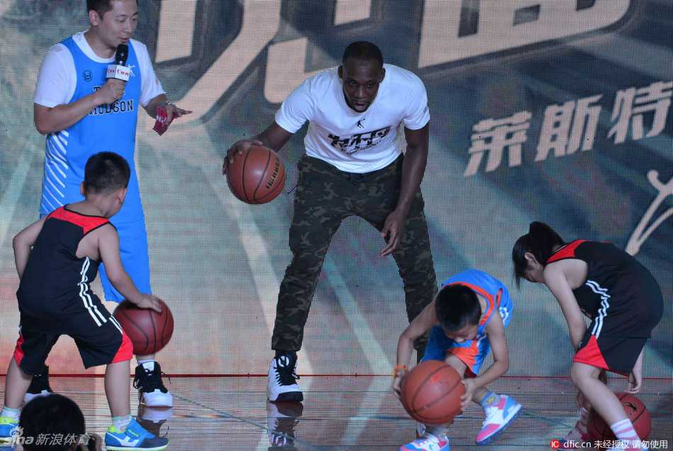 哈德森抱着女儿站在台上，父女俩一起俯瞰台下密密麻麻的球迷，女儿的小手搭在爸爸肩上，画面充满了温情与归属感。