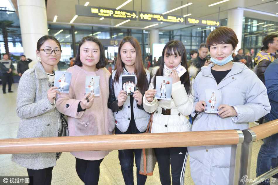 一位女球迷在人群中高高举起手中的赵继伟海报，脸上满是终于见到偶像的兴奋与满足，眼神中闪烁着光芒。