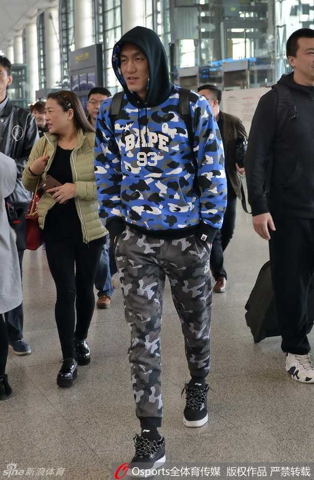 郭艾伦低垂着眉眼，手中的签字笔却一刻不停，为身旁热切的女球迷在球衣上留下专属印记。