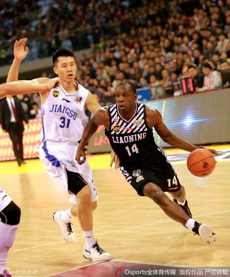 奥登身着便装坐在场边观战，眼神深邃而复杂，他手戴厚重的护具，仿佛在诉说着那些被伤病侵蚀的岁月。