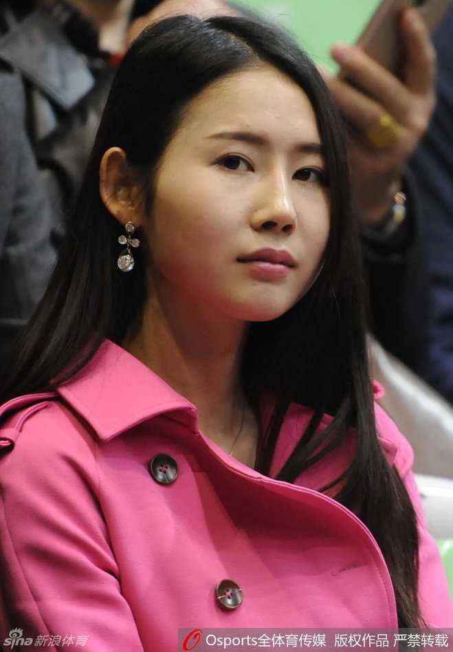 辽宁男篮球员贺天举坐在观众席上，身着便装，眼神中透露出对比赛的渴望和对队友的关切