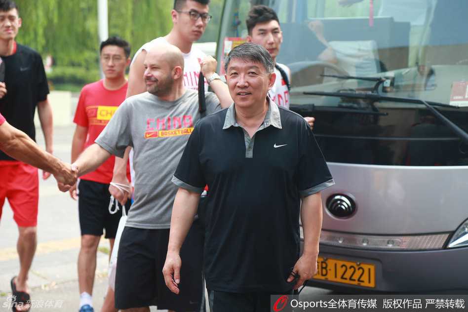 核心易建联身披红色战袍踏入球馆，神情轻松地整理着训练装备，他身旁的年轻队员们眼神中充满了对这位老大哥的依赖与敬意。