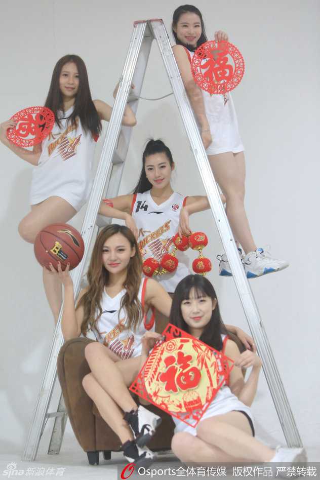 画面中的两位宝贝亲密相依，一袭红裙娇艳似火，一袭白衣纯洁如雪，她们手持红色折扇，对着镜头做出俏皮的新年手势，浓浓的喜庆氛围仿佛能透过画面感染每一个人。