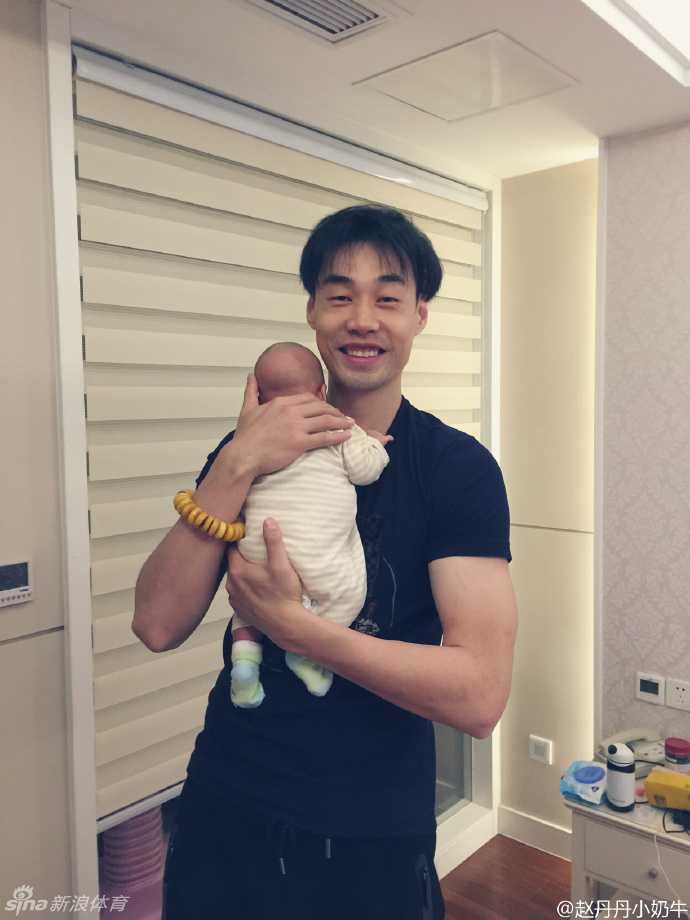 孟达笑容满面地给女儿换尿布，动作虽显笨拙却充满耐心，奶爸技能正在不断升级中。