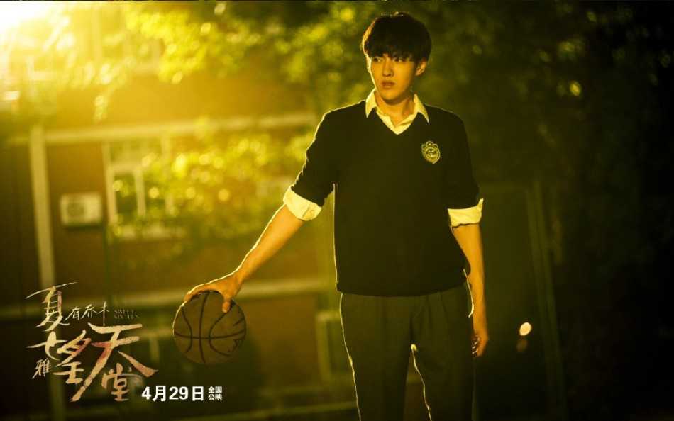 吴亦凡单手控球眼神专注，球衣随着动作微微扬起，将少年在球场上的专注与帅气展现得淋漓尽致