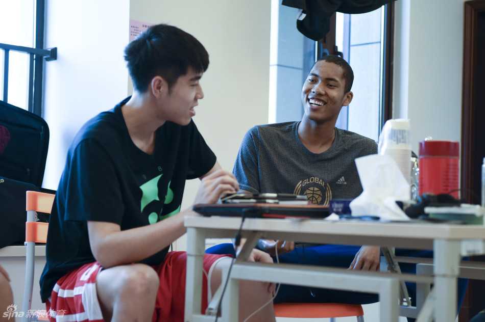 比赛暂停期间，丘天弯下腰，侧耳倾听主教练张云松的战术布置，眼神中充满对指令的信任与思索。