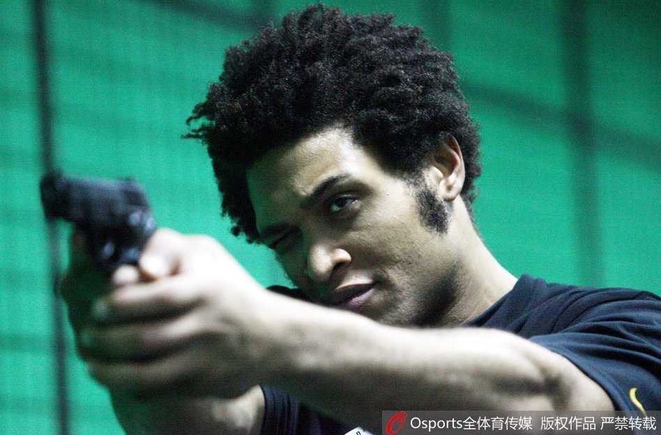 队长朱芳雨戴着耳罩，手持手枪，嘴角带着标志性的微笑扣动扳机，轻松打出十环的成绩，印证了他在赛场上的射手本色