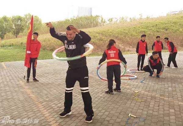 阿不都沙拉木在为篮球签名，神情专注而认真，笔尖在球面上缓缓移动，寄托着对球迷和公益的深情。