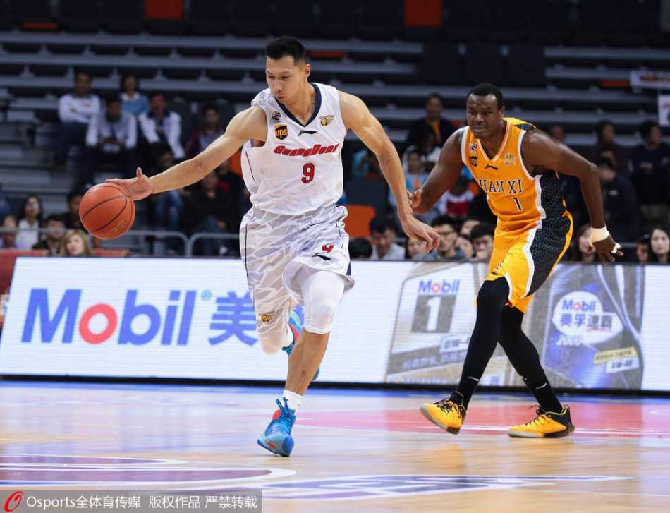 飞身暴扣永载史册:阿联篮球生涯的燃情瞬间与不朽传奇 眼神坚毅的易建联在场上全力要球,身后防守球员如影随形,领袖气质尽显无遗。