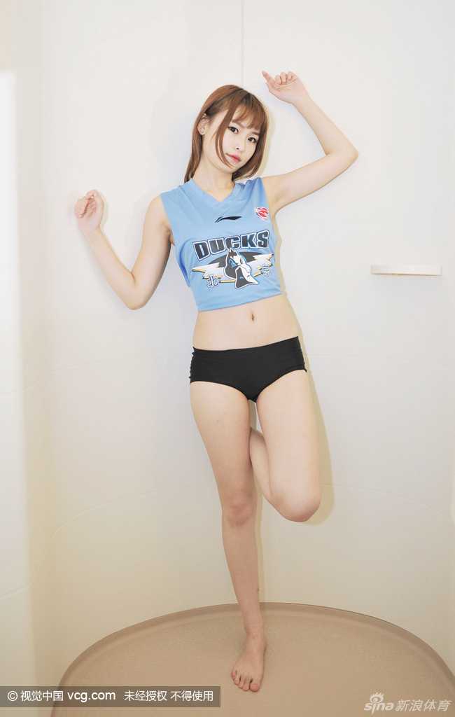 在洒满玫瑰花瓣的浴池边，一位宝贝赤足踏在光滑的地面上，微微踮起脚尖，展现出优美的脚踝和小腿曲线。她手持篮球，轻轻依靠在墙壁，将篮球宝贝的身份元素与生活化的浴室场景巧妙融合，创意十足。