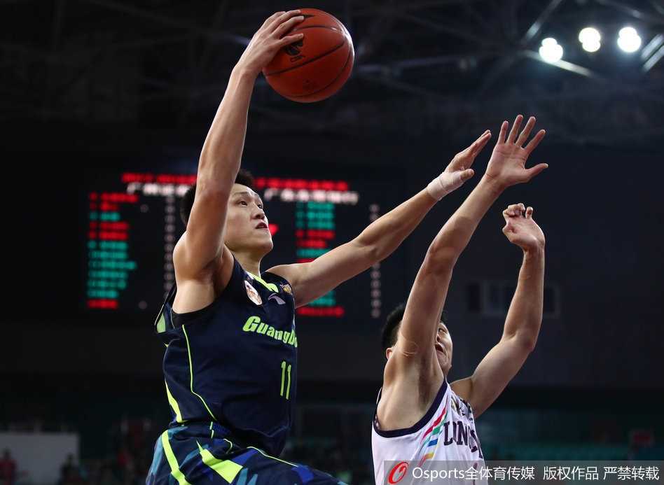 广东宏远主教练尤纳斯在场边大声指挥，他手臂挥舞，表情严肃，眼神中透露出对胜利的无限渴望