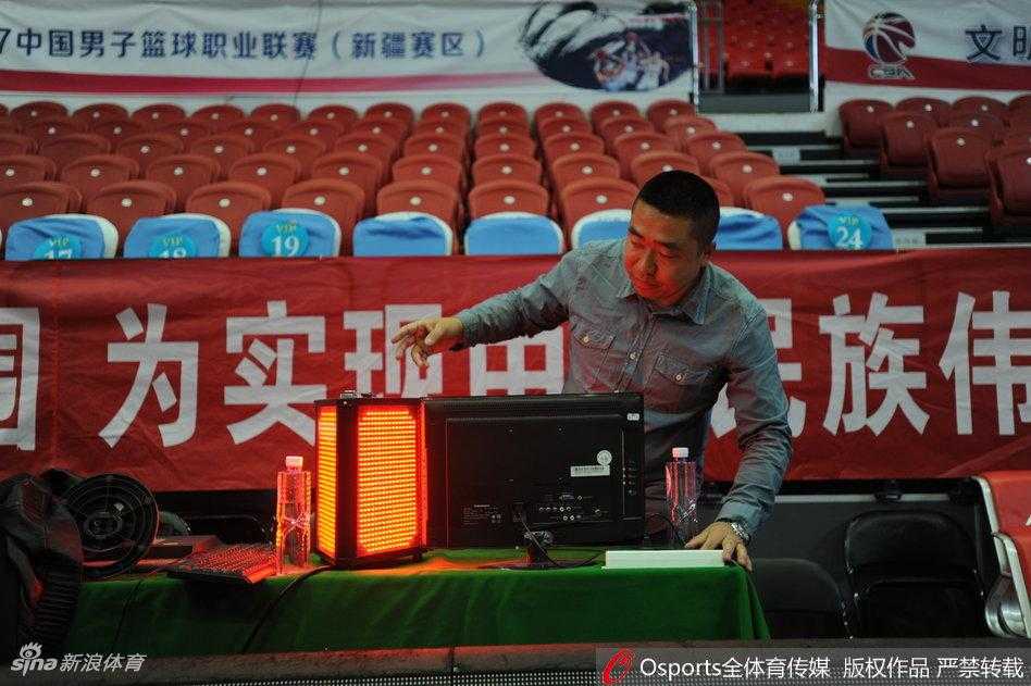 在比赛开始前的寂静中，工作人员正在对一条关键的信号线路进行检修，这条线路连接着场边的计时器与记录台，是保障比赛顺畅进行的信息生命线