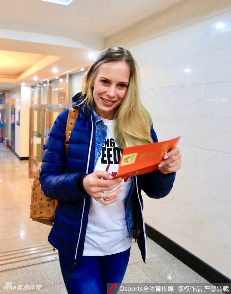 宝莲娜身着一袭简约的浅色针织衫，脸庞在体育馆明亮的灯光下显得格外精致，微微一笑便如春风拂面。