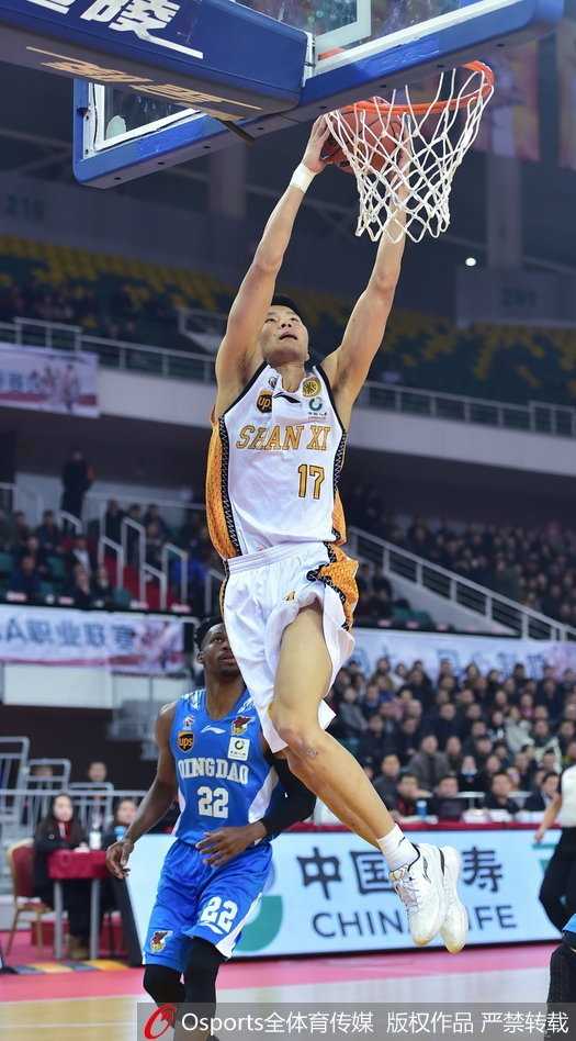 青岛队核心吉布森面对山西队两人的包夹防守，毫无惧色，强行突破上篮，展现出他超强的个人得分能力和不屈的斗志。