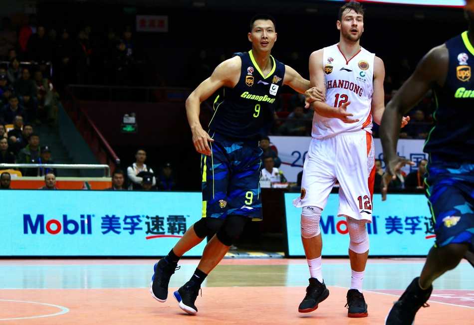 广东核心易建联在三人合围中拼抢篮球，眼神坚毅，誓要为球队夺回领先优势