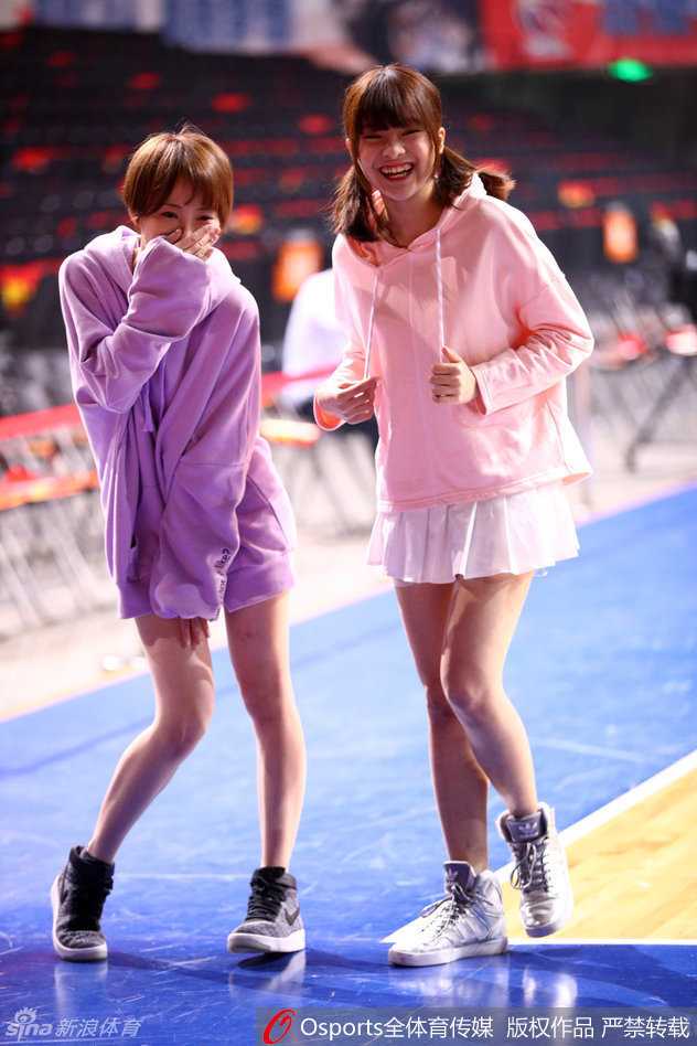 镜头拉近，一名GNZ48成员扎着高马尾，眼神专注而明亮，她手持话筒正在为广东德比激情献唱，身后的巨型LED屏幕闪烁着CBA季后赛的炽热灯光。