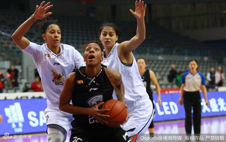 广东队外援约翰逊在新疆队高大的内线群中强行起跳上篮，眼神中充满了对胜利的渴望，肌肉的碰撞声仿佛穿透了屏幕。