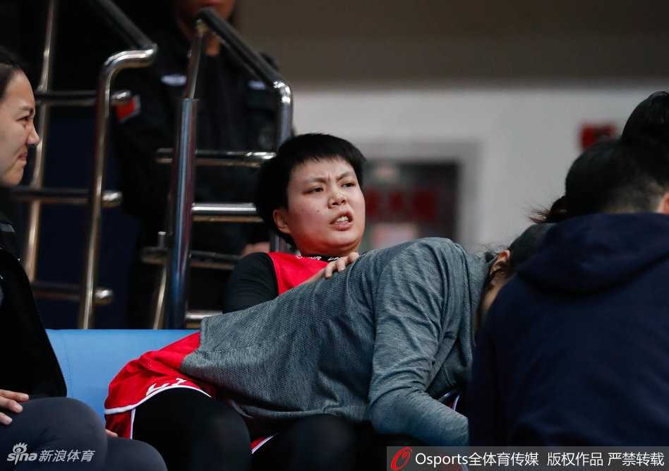 北京队主教练张云松在暂停期间，手持战术板蹲在地上，神情严肃地向队员们面授机宜，队员们围成一圈认真聆听。