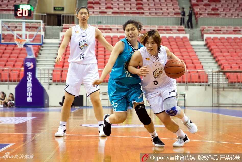 广东队后卫在三分线外果断出手，皮球在空中划出一道弧线，防守球员奋力扑防，指尖几乎触及篮球。