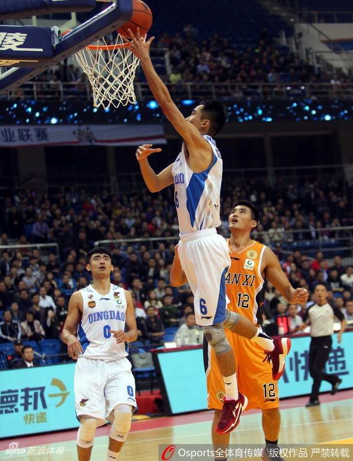 山西队球员曾令旭运球突破，青岛队的防守球员紧贴不放，双方在高速对抗中肌肉碰撞，气氛紧张。