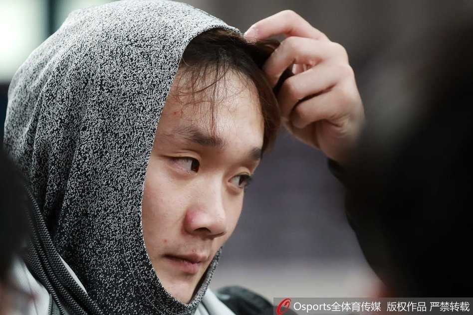 面对外界对发型的种种议论，小丁在镜头前露出一丝神秘而无奈的笑容，手里似乎正拿着准备包头的装备。