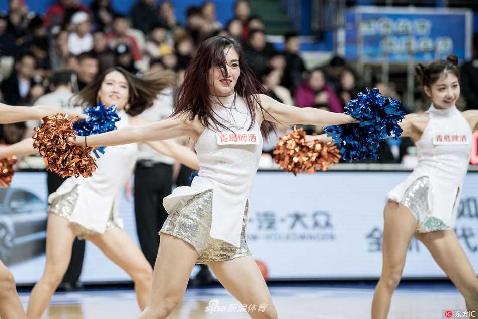 镜头特写下，一位扎着高马尾的啦啦队女孩眼神专注而自信，精致的五官和甜美的妆容在灯光下格外耀眼