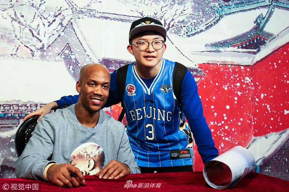 马布里双手接过小球迷送上的生日蛋糕，笑容中带着惊喜与感动，蛋糕上的蜡烛映照出他微红的眼眶