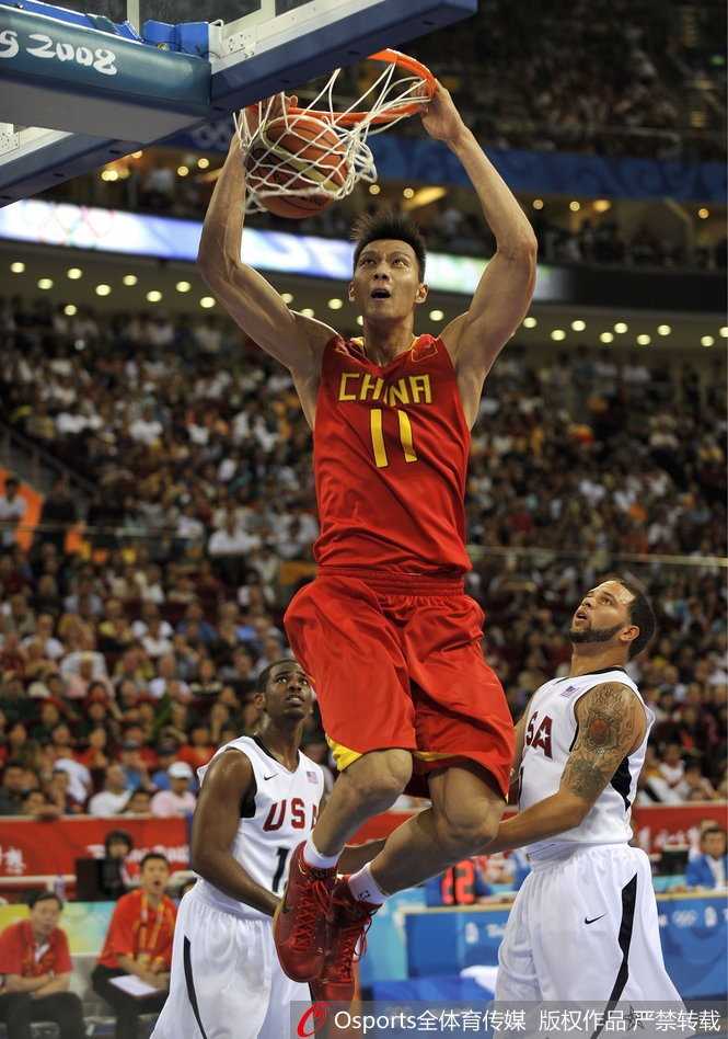 身披红色战袍的姚明在内线一柱擎天，面对立陶宛多名球员的围堵，依然高高跃起，试图将球送入篮筐。