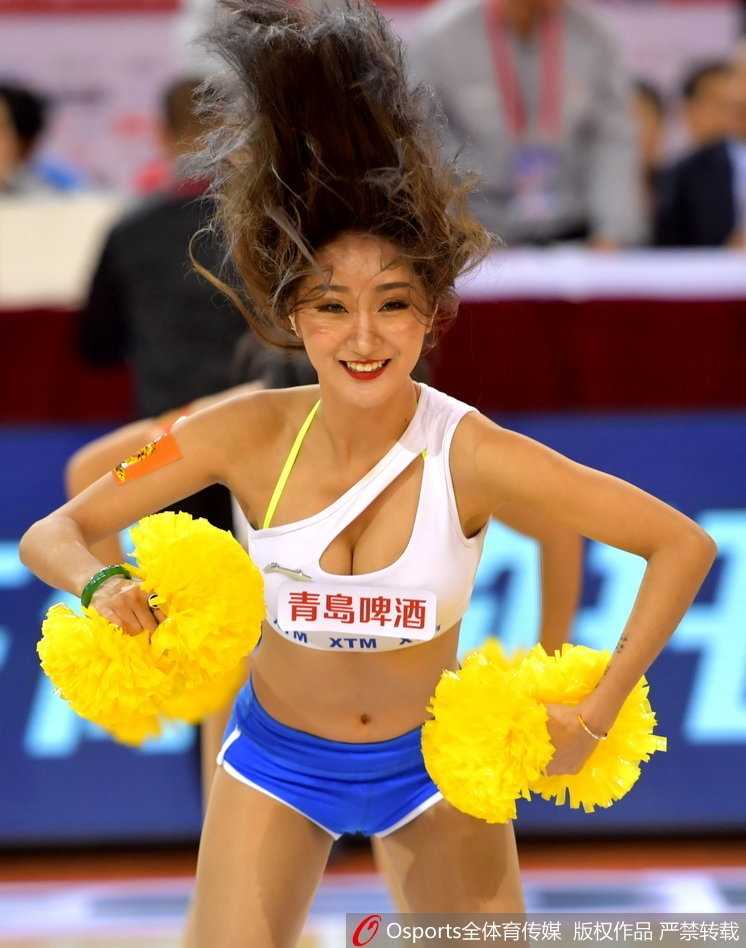 镜头拉近，这位篮球宝贝回眸一笑，甜美的面容与飘逸的长发在灯光下显得格外迷人