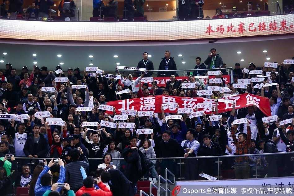 几名年轻的辽宁男球迷在客队球迷区搭着肩膀，他们面红耳赤，青筋暴起，正冲着场内发出震耳欲聋的加油声，全然不顾周围主队球迷的目光